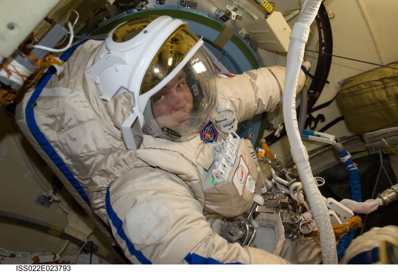 ISS022-E-023793 (12 Jan. 2010) --- Attired in a Russian Orlan spacesuit, Russian cosmonaut Maxim Suraev, Expedition 22 flight engineer, checks out his Orlan suit in preparation for a spacewalk scheduled for Jan. 14 to outfit the new Poisk module for future Russian vehicle dockings.