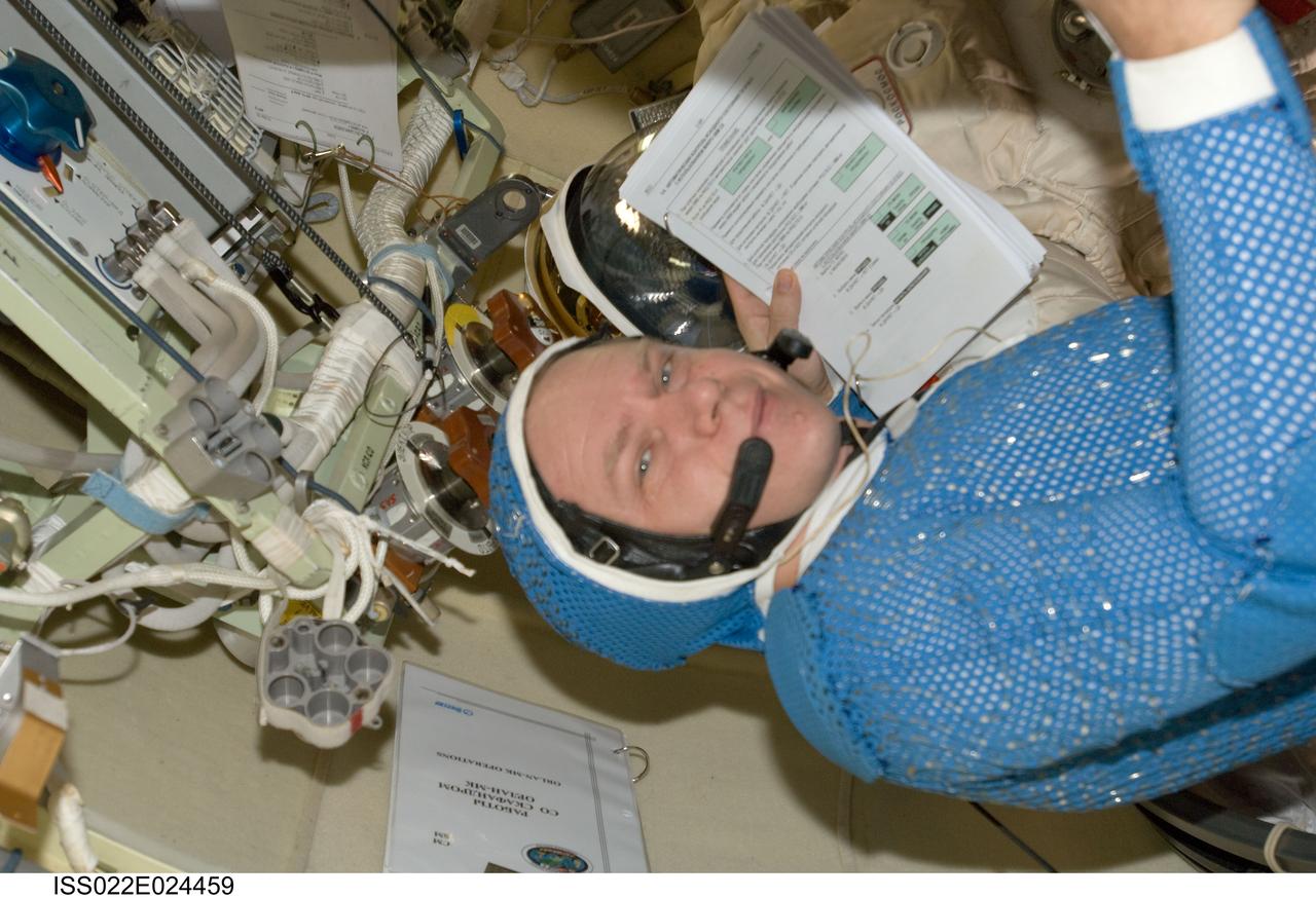 ISS022-E-024459 (12 Jan. 2010) --- Attired in a blue thermal undergarment that complements the Russian Orlan spacesuit, Russian cosmonaut Oleg Kotov, Expedition 22 flight engineer, is pictured in the Pirs Docking Compartment of the International Space Station.