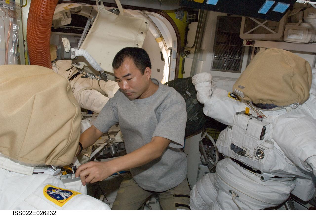 ISS022-E-026232 (18 Jan. 2010) --- Japan Aerospace Exploration Agency (JAXA) astronaut Soichi Noguchi, Expedition 22 flight engineer, works with an Extravehicular Mobility Unit (EMU) spacesuit in the Quest Airlock of the International Space Station.