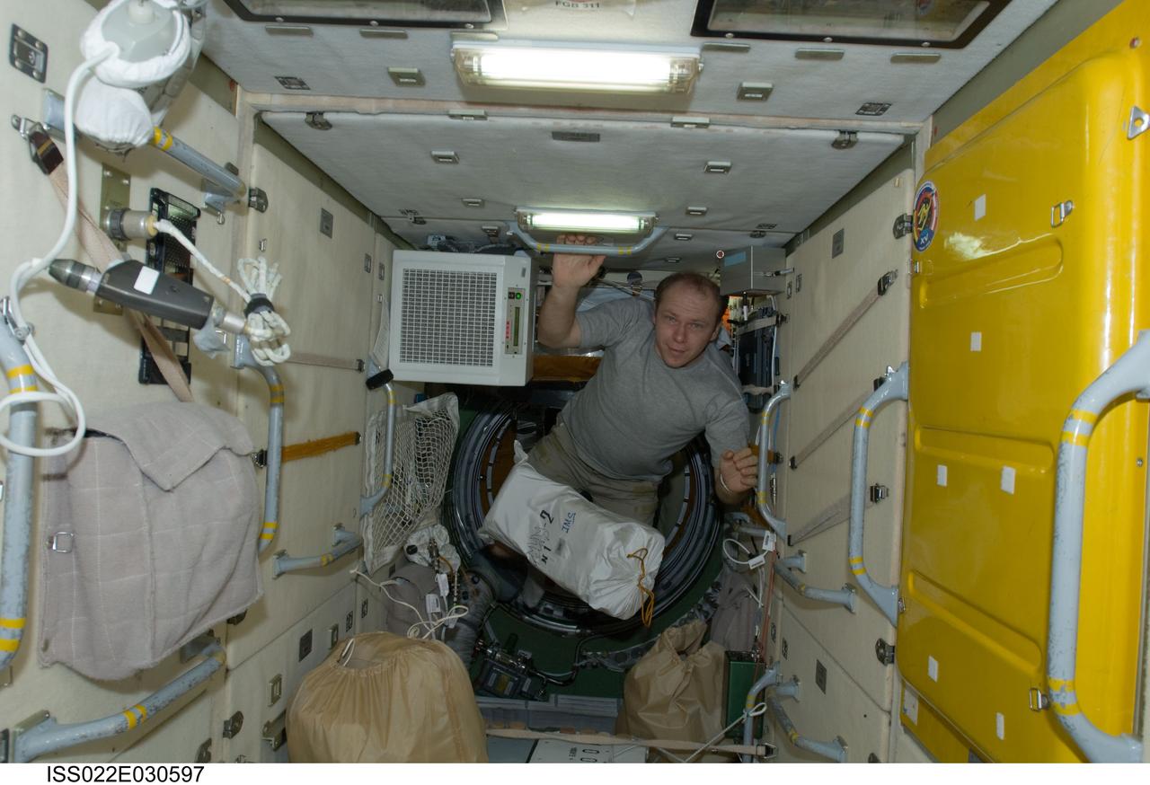 ISS022-E-030597 (19 Jan. 2010) --- Russian cosmonaut Oleg Kotov, Expedition 22 flight engineer, is pictured near a stowage bag floating freely in the Zarya Functional Cargo Block (FGB) of the International Space Station.