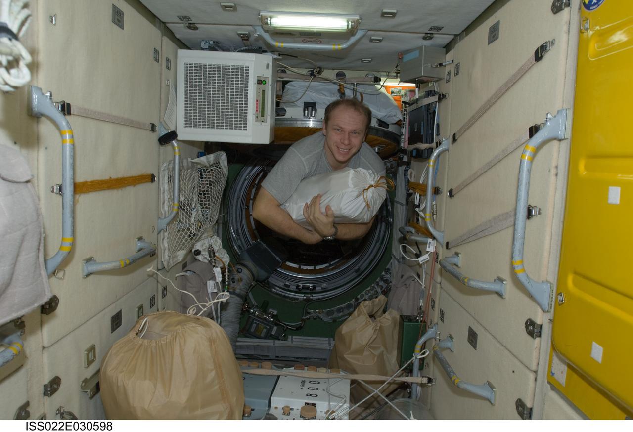 ISS022-E-030598 (19 Jan. 2010) --- Russian cosmonaut Oleg Kotov, Expedition 22 flight engineer, moves a stowage bag in the Zarya Functional Cargo Block (FGB) of the International Space Station.