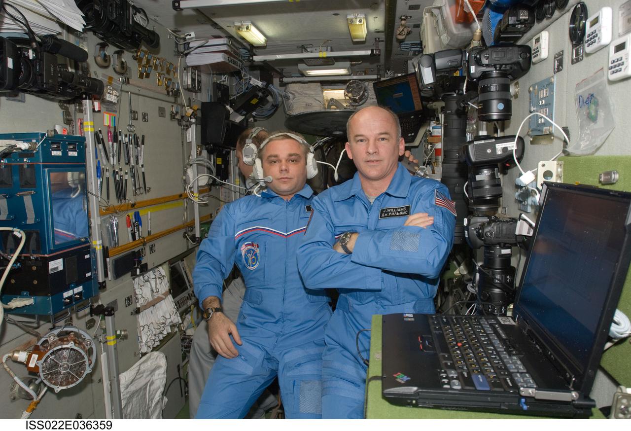 ISS022-E-036359 (20 Jan. 2010) --- NASA astronaut Jeffrey Williams (right), Expedition 22 commander; along with Russian cosmonauts Maxim Suraev and Oleg Kotov (background), both flight engineers, are pictured in the Zvezda Service Module of the International Space Station.