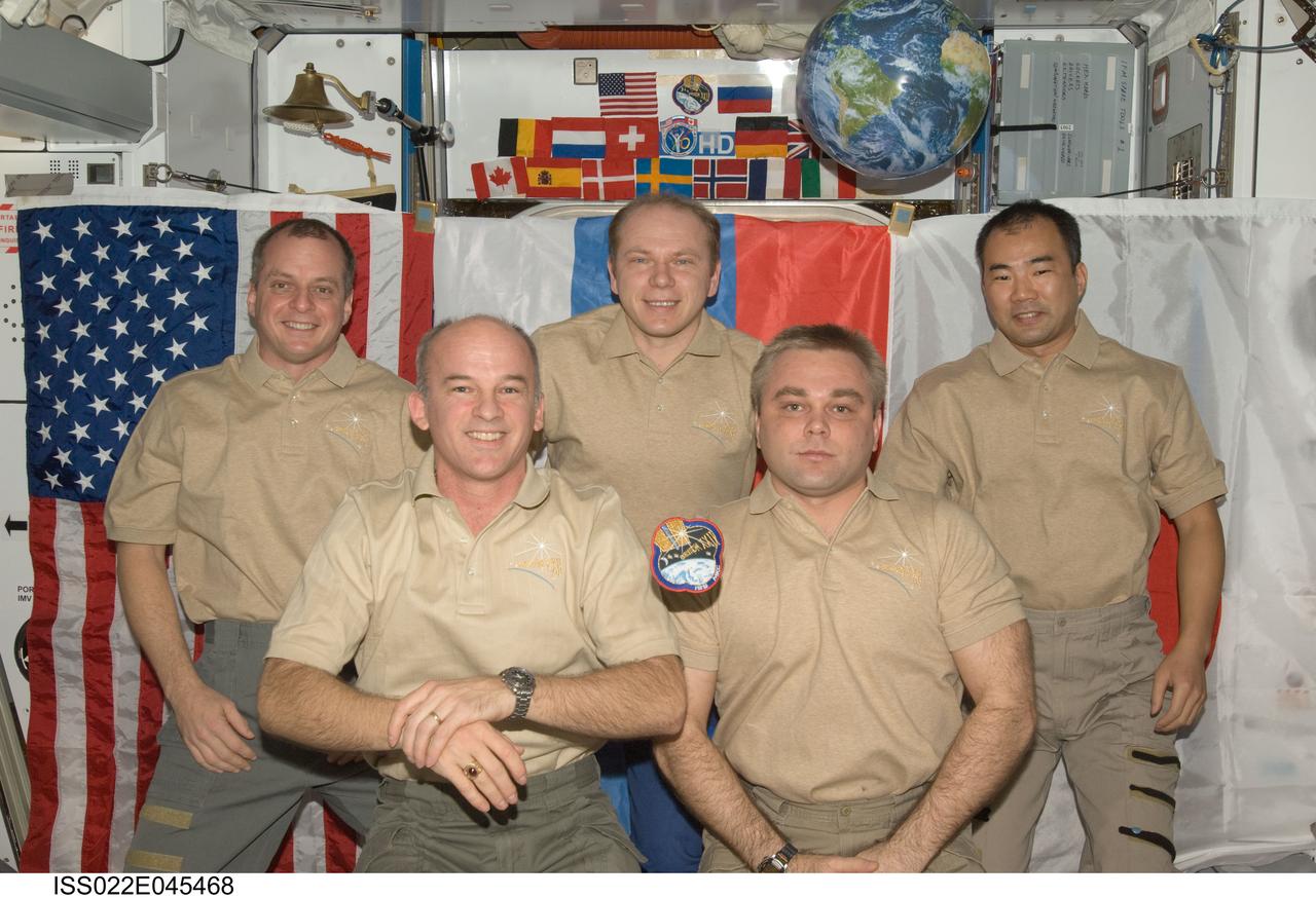 ISS022-E-045468 (31 Jan. 2010) --- The Expedition 22 crew members pose for an in-flight crew portrait in the Harmony node of the International Space Station. From the left (front row) are NASA astronaut Jeffrey Williams, commander; and Russian cosmonaut Maxim Suraev, flight engineer. From the left (back row) are NASA astronaut T.J. Creamer, Russian cosmonaut Oleg Kotov and Japan Aerospace Exploration Agency (JAXA) astronaut Soichi Noguchi, all flight engineers. The Expedition 22 patch floats freely in the foreground.
