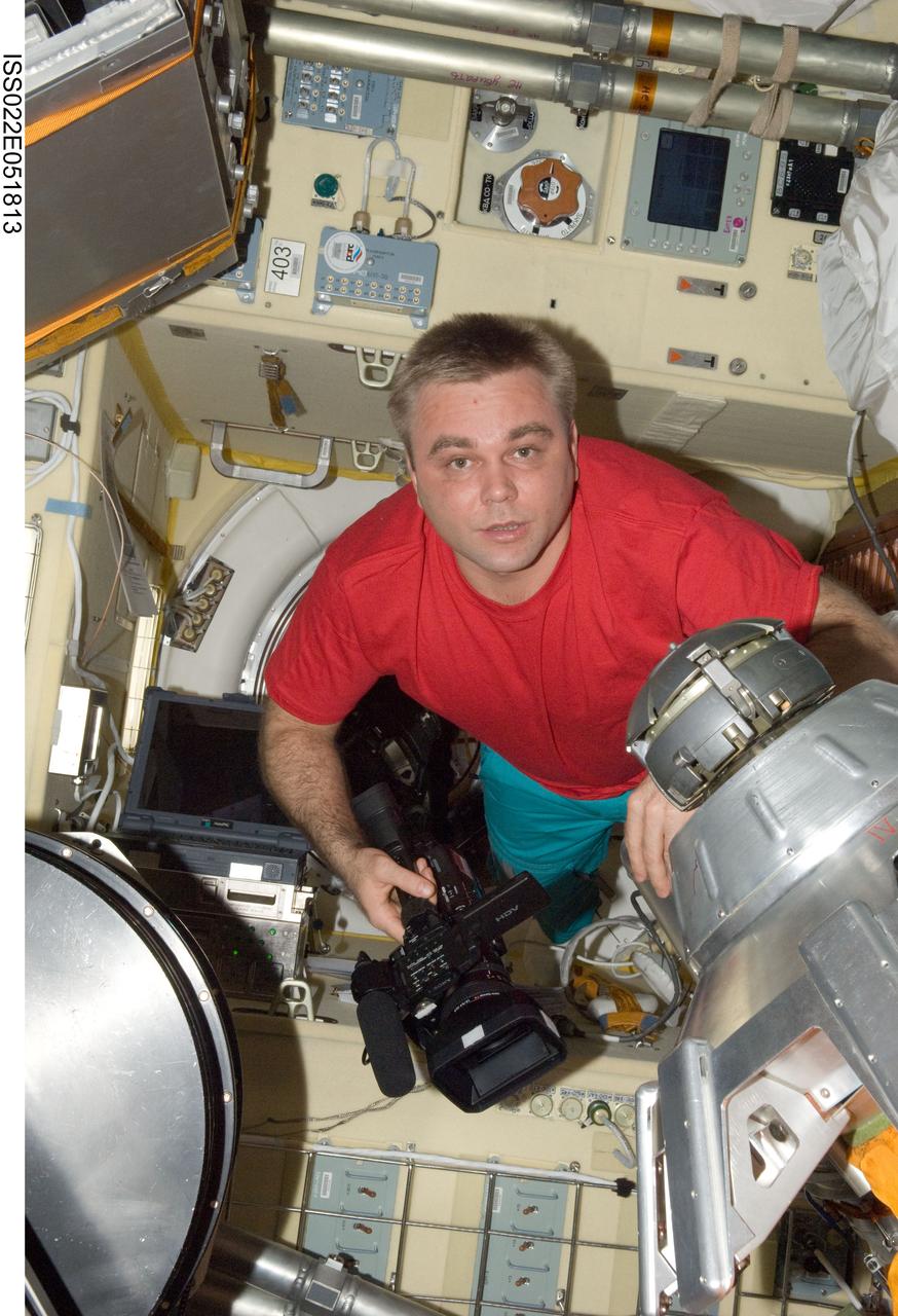 ISS022-E-051813 (28 Jan. 2010) --- Russian cosmonaut Maxim Suraev, Expedition 22 flight engineer, holds a High Definition Video (HDV) camera in the in the Zvezda Service Module transfer compartment of the International Space Station.