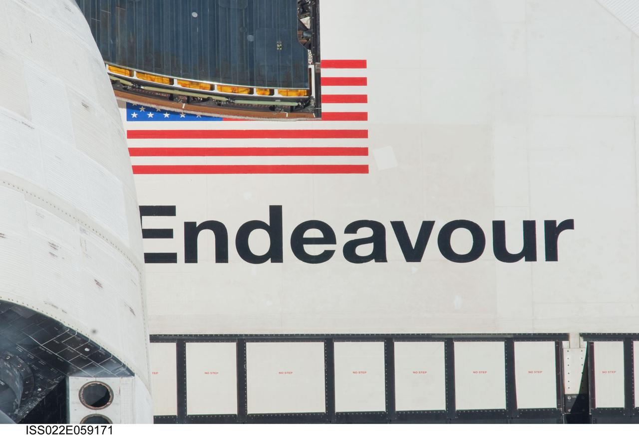 ISS022-E-059171 (9 Feb. 2010) --- This 800mm lens's image of part of space shuttle Endeavour's starboard wing, displaying the orbiter's name and the U.S. flag, was photographed during the rendezvous operations between the shuttle and the International Space Station, which included a back-flip by the shuttle.