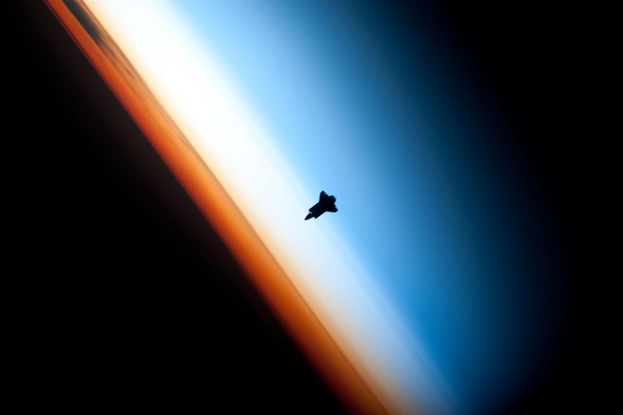 ISS022-E-062672 (9 Feb. 2010) --- Though astronauts and cosmonauts often encounter striking scenes of Earth's limb, this very unique image, part of a series over Earth's colorful horizon, has the added feature of a silhouette of the space shuttle Endeavour. The image was photographed by an Expedition 22 crew member prior to STS-130 rendezvous and docking operations with the International Space Station. Docking occurred at 11:06 p.m. (CST) on Feb. 9, 2010. The orbital outpost was at 46.9 south latitude and 80.5 west longitude, over the South Pacific Ocean off the coast of southern Chile with an altitude of 183 nautical miles when the image was recorded. The orange layer is the troposphere, where all of the weather and clouds which we typically watch and experience are generated and contained. This orange layer gives way to the whitish Stratosphere and then into the Mesosphere. In some frames the black color is part of a window frame rather than the blackness of space.