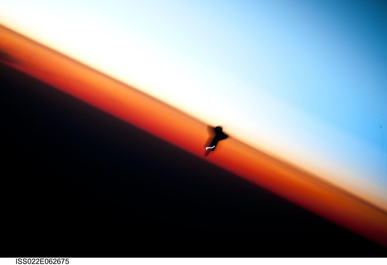 ISS022-E-062675 (9 Feb. 2010) --- Though astronauts and cosmonauts often encounter striking scenes of Earth's limb, this very unique image, part of a series over Earth's colorful horizon, has the added feature of a silhouette of the space shuttle Endeavour. The image was photographed by an Expedition 22 crew member prior to STS-130 rendezvous and docking operations with the International Space Station. Docking occurred at 11:06 p.m. (CST) on Feb. 9, 2010. The orbital outpost was at 46.9 south latitude and 80.5 west longitude, over the South Pacific Ocean off the coast of southern Chile with an altitude of 183 nautical miles when the image was recorded. The orange layer is the troposphere, where all of the weather and clouds which we typically watch and experience are generated and contained. This orange layer gives way to the whitish Stratosphere and then into the Mesosphere. In some frames the black color is part of a window frame rather than the blackness of space.