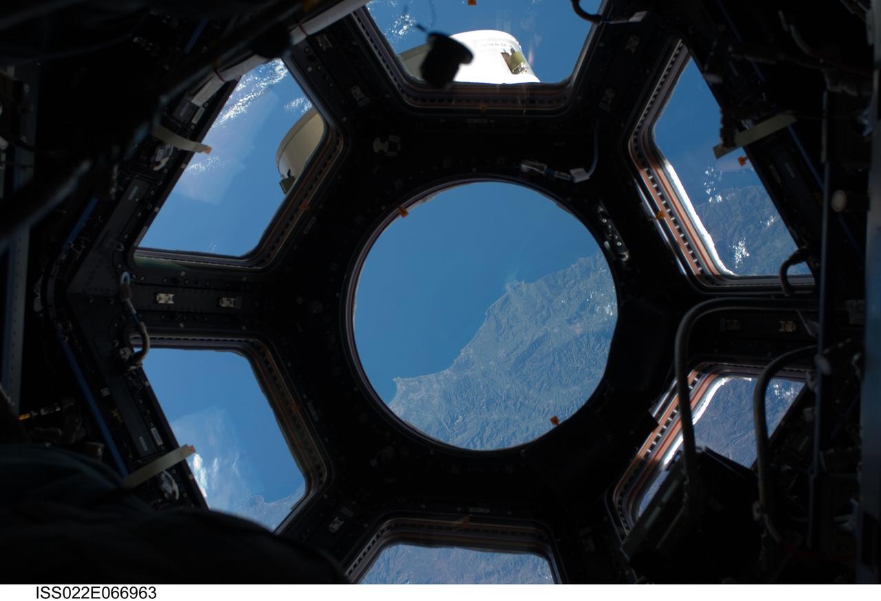 ISS022-E-066963 (17 Feb. 2010) --- This image is among the first taken through a first of its kind ?bay window? on the International Space Station, the seven-windowed Cupola. The image shows the coast of Algeria featuring (in the Cupola?s round window) an area between the cities of Dellys and Algiers. The image was recorded with a digital still camera using a 28mm lens setting. The Cupola, which a week and half ago was brought up to the orbital outpost by the STS-130 crew on the space shuttle Endeavour, will house controls for the station robotics and will be a location where crew members can operate the robotic arms and monitor other exterior activities.