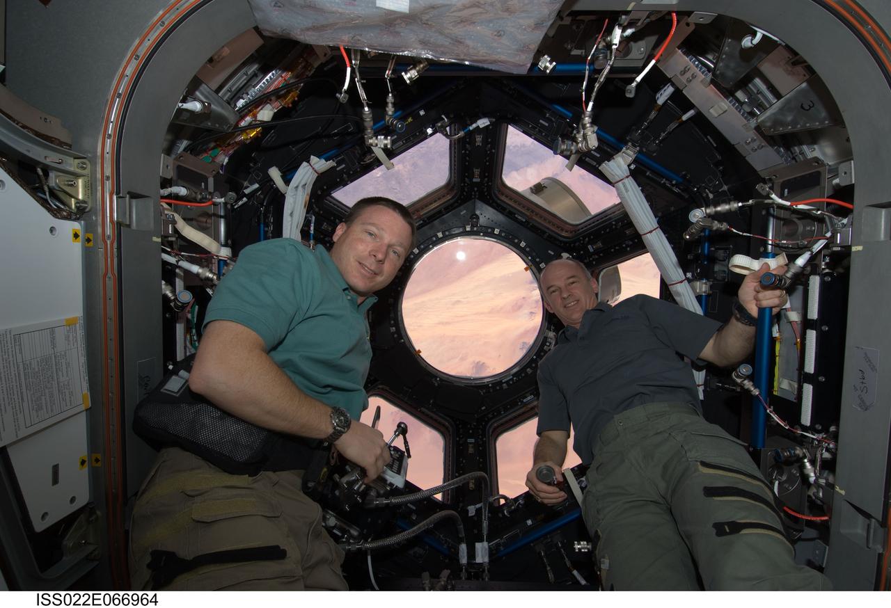 ISS022-E-066964 (17 Feb. 2010) --- NASA astronauts Terry Virts (left), STS-130 pilot; and Jeffrey Williams, Expedition 22 commander, pose for a photo near the windows in the newly-installed Cupola of the International Space Station while space shuttle Endeavour remains docked with the station.