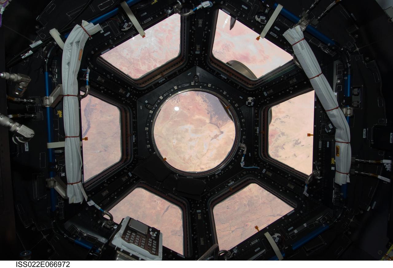 ISS022-E-066972 (17 Feb. 2010) --- This image is the first taken through a first of its kind “bay window” on the International Space Station, the seven-windowed Cupola. The image shows the Sahara Desert spread out through the array of windows. The Cupola will house controls for the station robotics and will be a location where crew members can operate the robotic arms and monitor other exterior activities. The location of the image is in Sudan near Al Fashir. Center of the round window is looking at 14.68 degrees north latitude and 26.74 east longitude, recorded with a 12-24mm zoom lens.