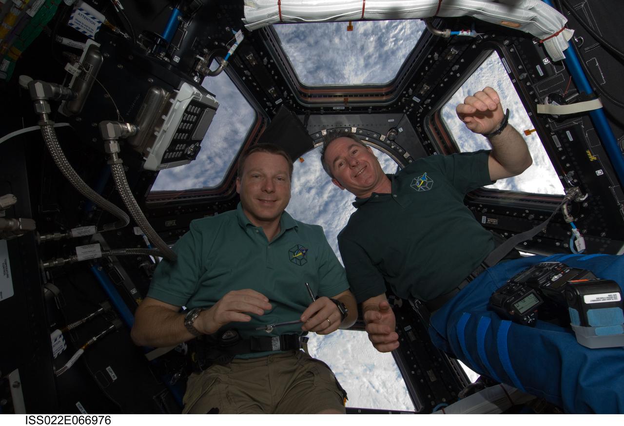 ISS022-E-066976 (17 Feb. 2010) --- NASA astronauts Terry Virts (left), STS-130 pilot; and Stephen Robinson, mission specialist, pose for a photo near the windows in the newly-installed Cupola of the International Space Station while space shuttle Endeavour remains docked with the station.