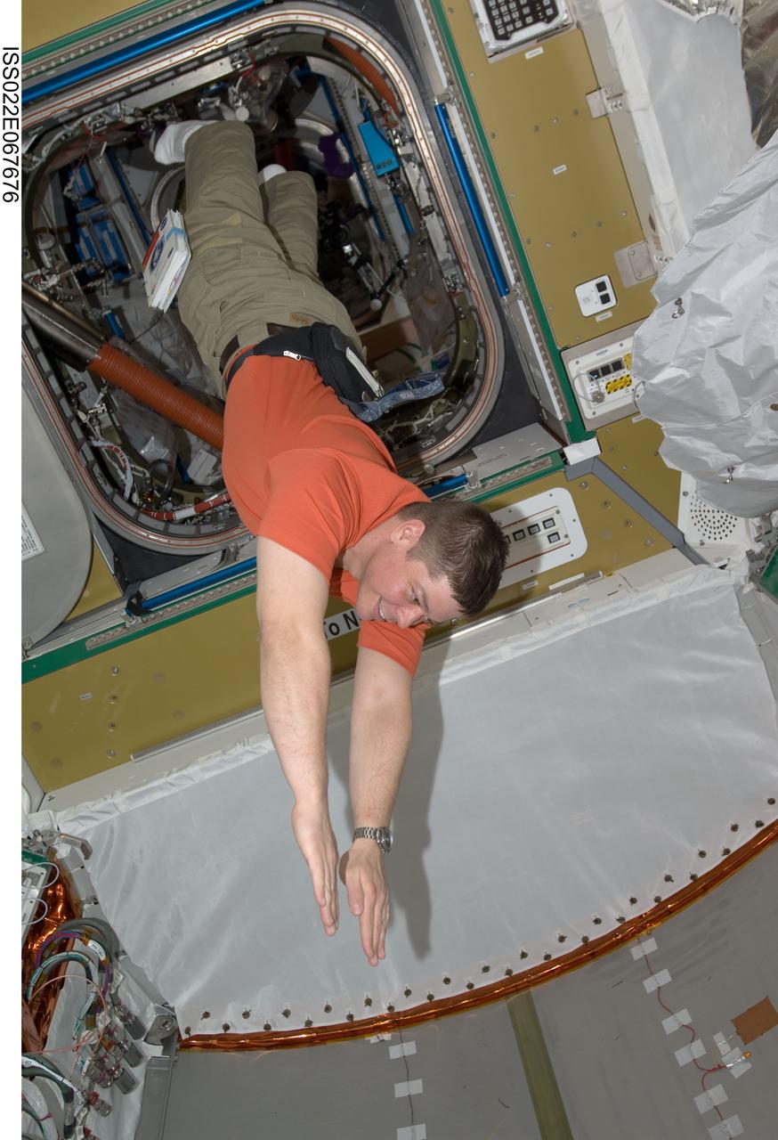 ISS022-E-067676 (14 Feb. 2010) --- NASA astronaut Robert Behnken, STS-130 mission specialist, floats freely in newly-installed Tranquility node of the International Space Station while space shuttle Endeavour remains docked with the station.