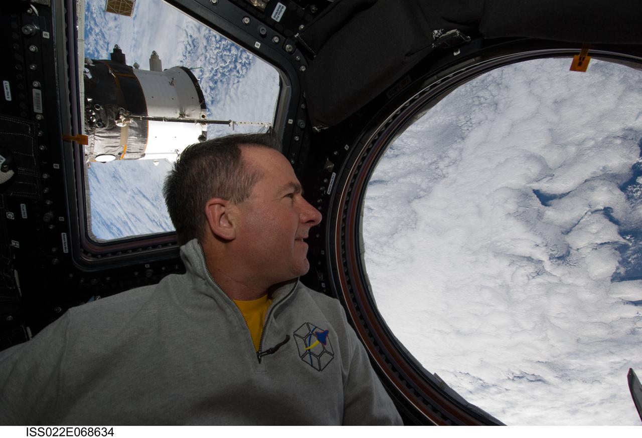 Robinson plays guitar in the Cupola Module during Joint Operations