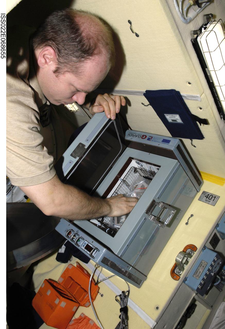 ISS022-E-068655 (19 Feb. 2010) --- Russian cosmonaut Oleg Kotov, Expedition 22 flight engineer, collects samples from the new bioscience experiment ASEPTIC (BTKh-39) in the Poisk Mini-Research Module 2 (MRM2) of the International Space Station.
