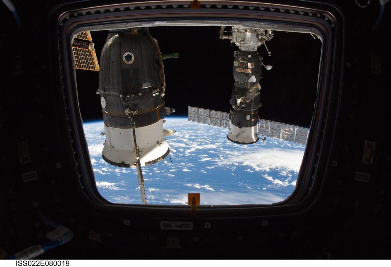 ISS022-E-080019 (3 March 2010) --- Two Russian spacecraft, docked with the International Space Station, are featured in this image photographed by an Expedition 22 crew member from a window in the station’s Cupola. Earth's horizon and the blackness of space form the backdrop for the scene.