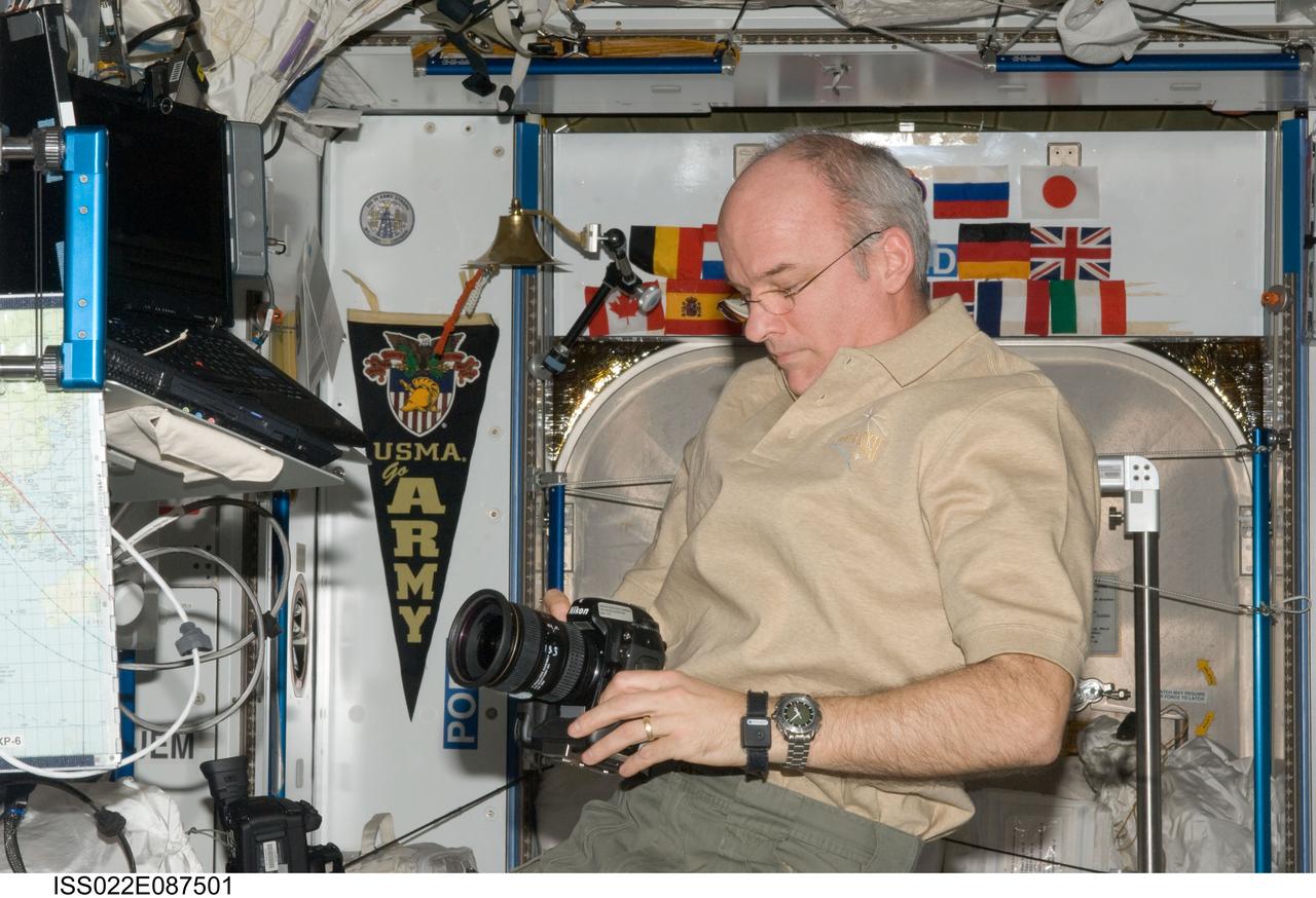 ISS022-E-087501 (7 March 2010) --- NASA astronaut Jeffrey Williams, Expedition 22 commander, prepares to use a still camera in the Harmony node of the International Space Station.