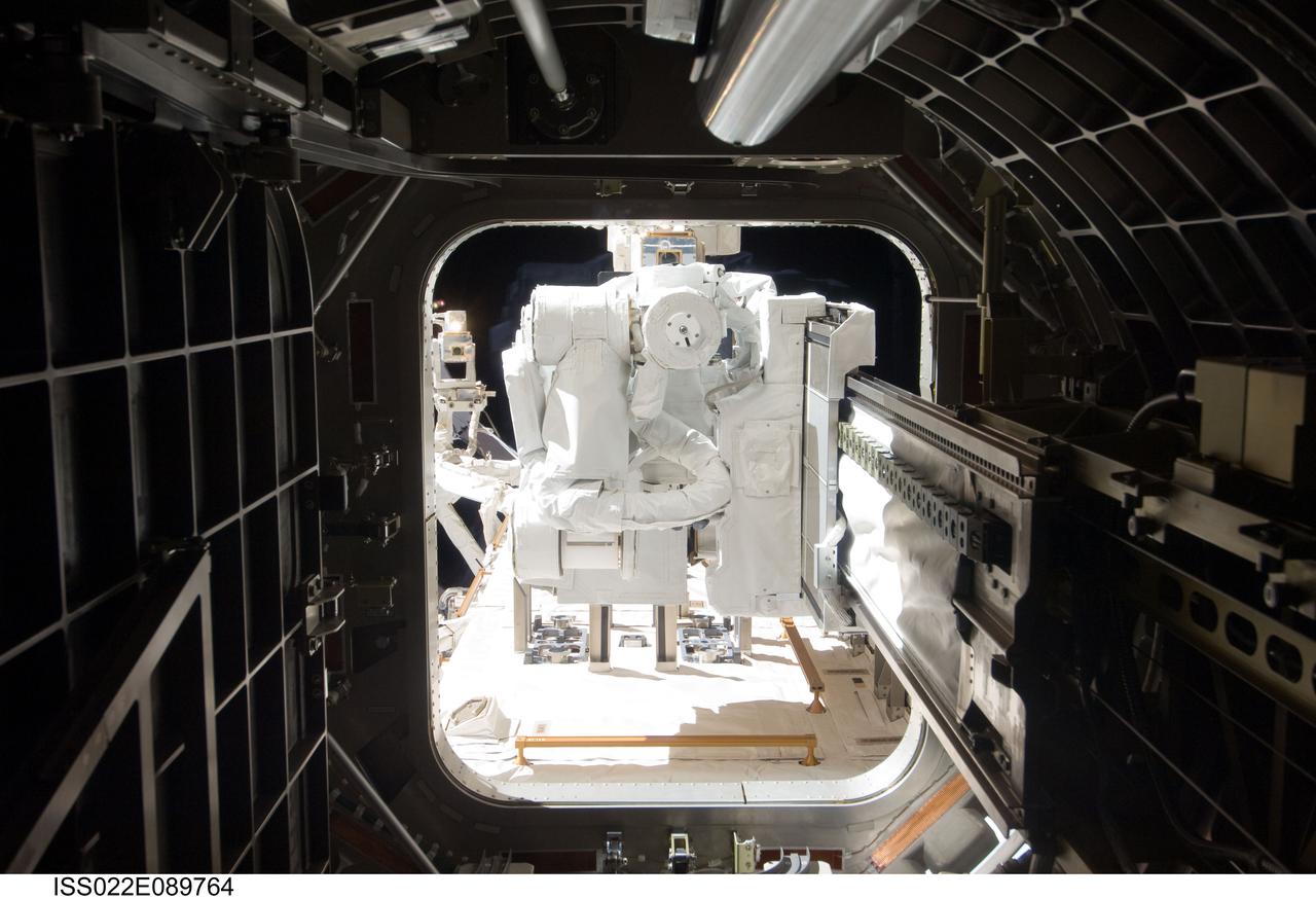 ISS022-E-089764 (10 March 2010) --- Looking through the Kibo airlock, the Japanese robotic Small Fine Arm (SFA), also known as ?Ko-bot?, is featured in this image photographed by an Expedition 22 crew member in the Kibo laboratory of the International Space Station during its installation on the external Japanese Experiment Module - Exposed Facility.