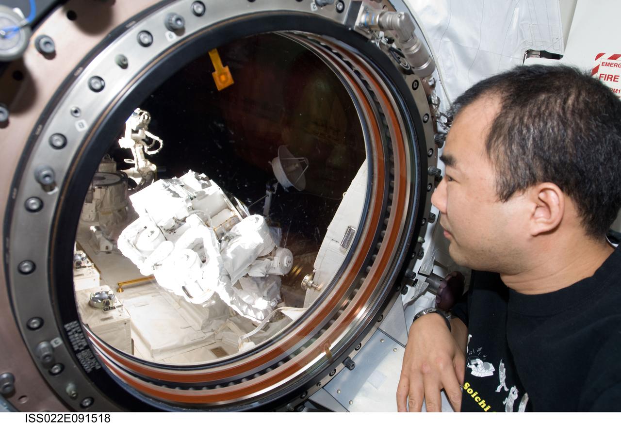 ISS022-E-091518 (12 March 2010) --- Japan Aerospace Exploration Agency (JAXA) astronaut Soichi Noguchi, Expedition 22 flight engineer, looks through a window in the Kibo laboratory of the International Space Station. The Japanese robotic Small Fine Arm (SFA), also known as ?Ko-bot?, is visible through the window.