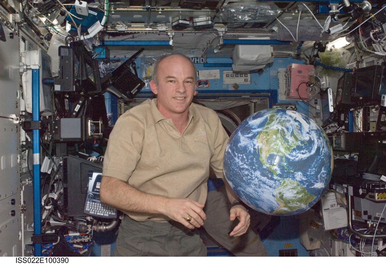 ISS022-E-100390 (17 March 2010) --- NASA astronaut Jeffrey Williams, Expedition 22 commander, poses for a photo near a globe floating freely in the Destiny laboratory of the International Space Station.