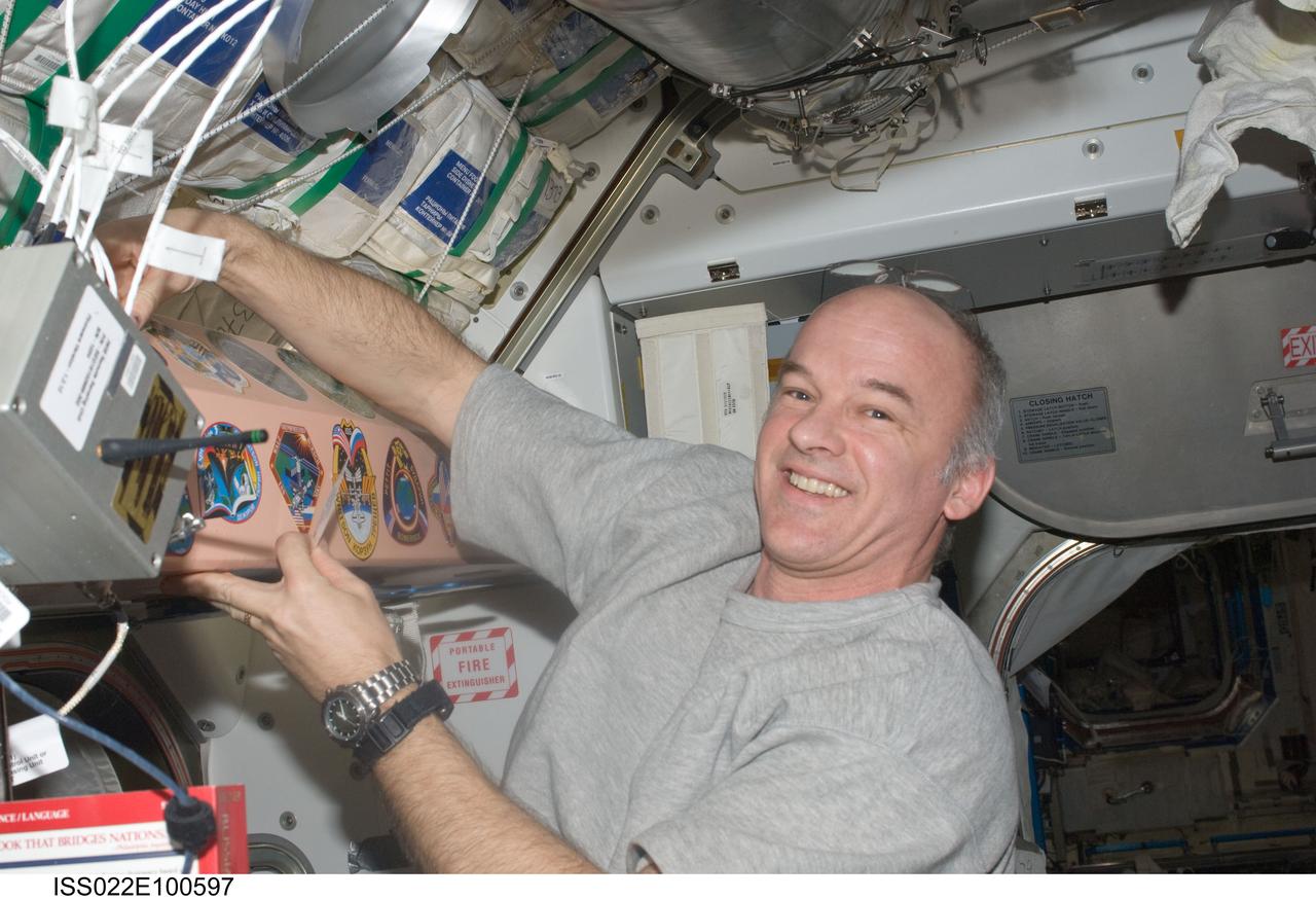 ISS022-E-100597 (17 March 2010) --- NASA astronaut Jeffrey Williams, Expedition 22 commander, places the Expedition 22 mission insignia along with others in the Unity node of the International Space Station.