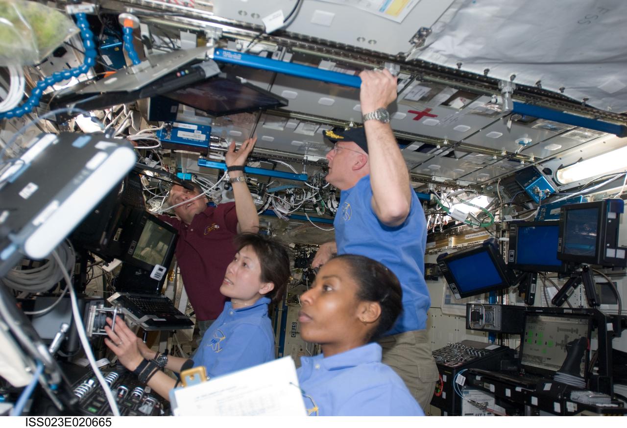 ISS023-E-020665 (7 April 2010) --- Japan Aerospace Exploration astronaut Naoko Yamazaki (near frame center) joins NASA astronauts Stephanie Wilson (foreground), Alan Poindexter (blue jersey, standing) and T.J. Creamer in the "busy" Destiny laboratory aboard the International Space Station. Creamer is Expedition 23 flight engineer, Poindexter is STS-131 commander and Yamazaki and Wilson are mission specialists for STS-131.