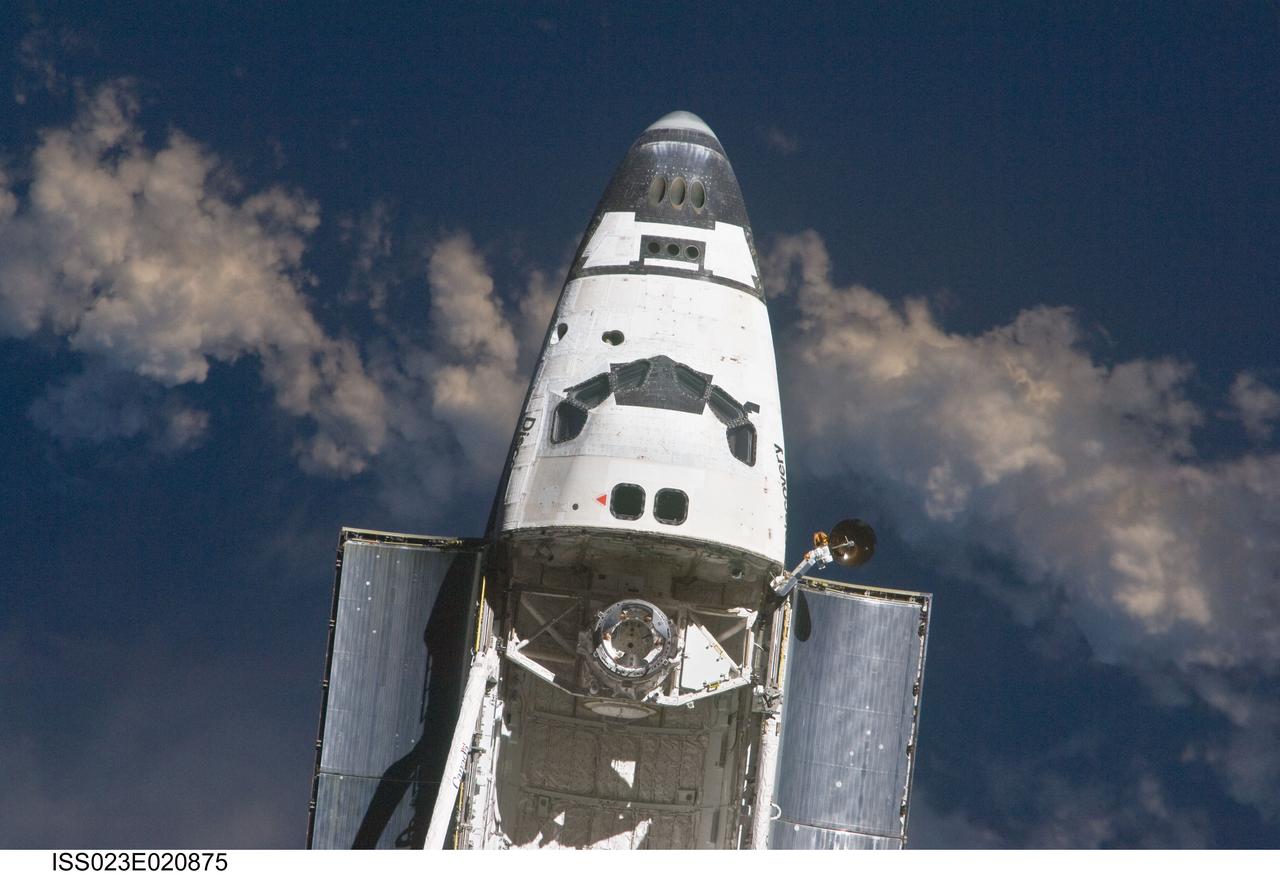ISS023-E-020875 (7 April 2010) --- The space shuttle Discovery and the International Space Station (out of frame) are in the midst of their rendezvous and docking activities in this image photographed by an Expedition 23 crew member aboard the orbital outpost.