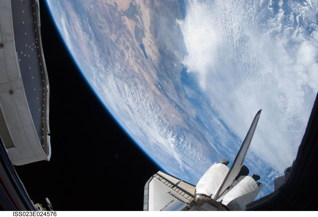 ISS023-E-024576 (15 April 2010) --- One of the Expedition 23 crew members aboard the International Space Station snapped this photo of part of the space shuttle Discovery’s starboard wing, vertical stabilizer and orbital maneuvering system pods backdropped against the cloud-covered Pacific Coast of southern California and northern Baja California, Mexico. The Imperial Valley and Salton Sea can be seen at top center.