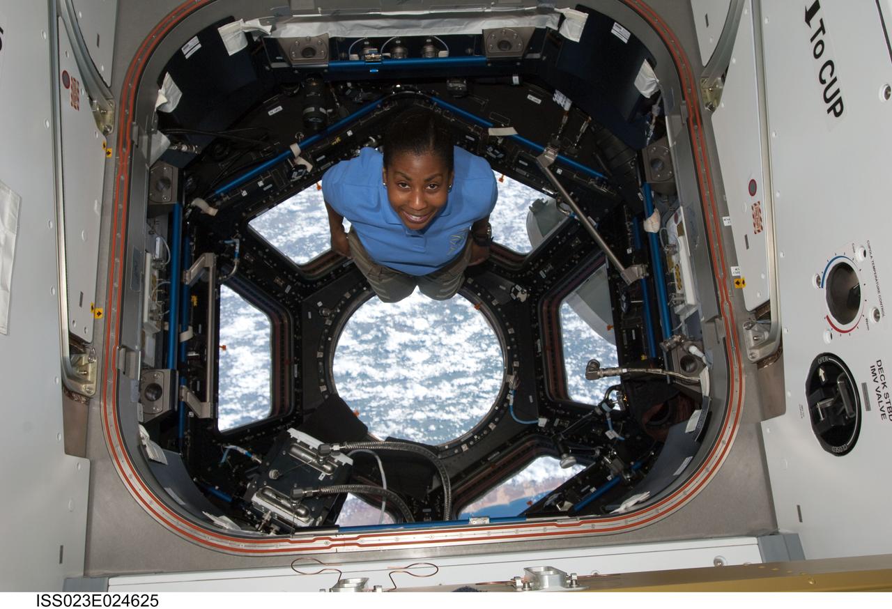ISS023-E-024625 (17 April 2010) --- NASA astronaut Stephanie Wilson, STS-131 mission specialist, poses for a photo in the Cupola of the International Space Station while space shuttle Discovery remains docked with the station.