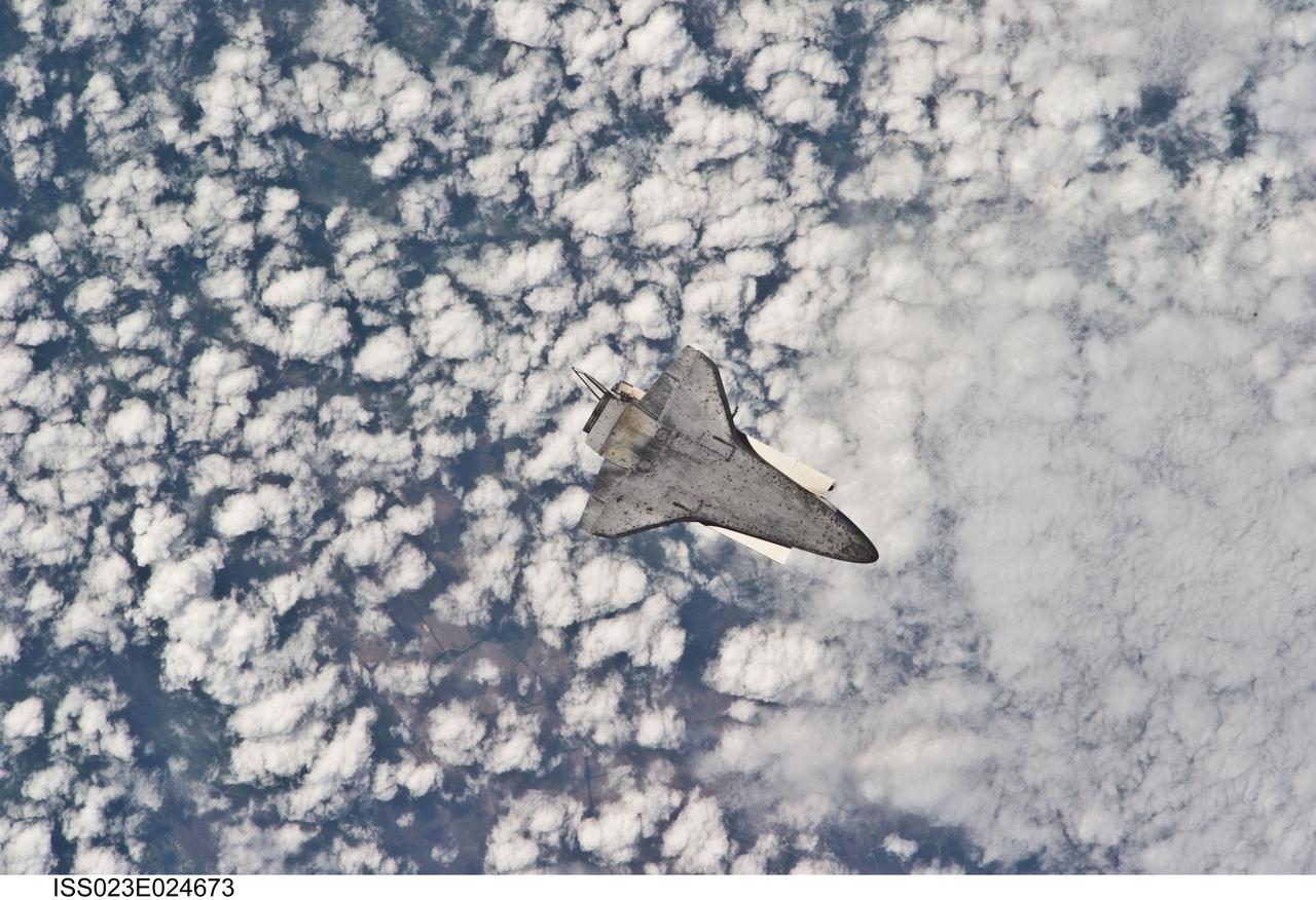 ISS023-E-024673 (17 April 2010) --- The space shuttle Discovery flies with its payload bay facing Earth so that the astronauts and cosmonauts onboard the International Space Station could survey and photograph it following the relative separation of the two spacecraft on April 17.