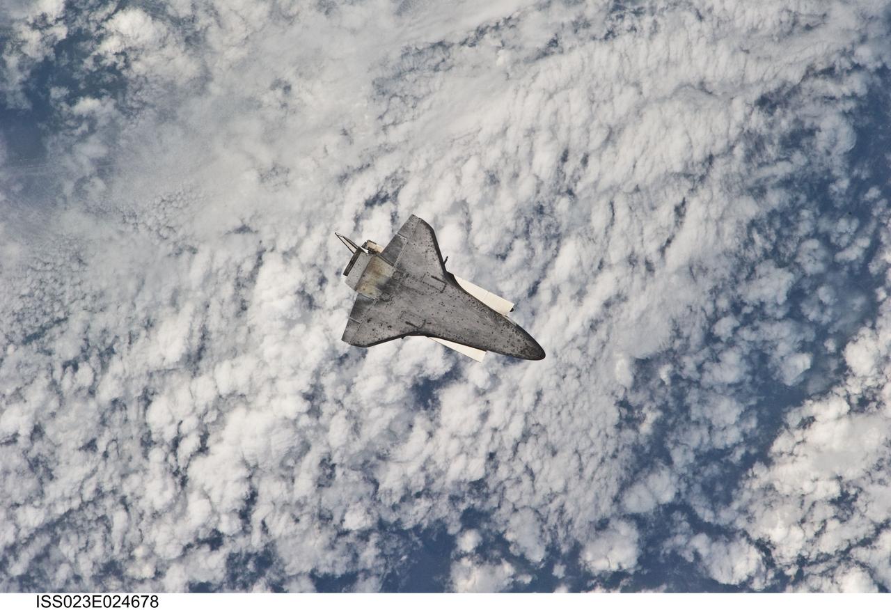 ISS023-E-024678 (17 April 2010) --- The space shuttle Discovery flies with its payload bay facing Earth so that the astronauts and cosmonauts onboard the International Space Station could survey and photograph it following the relative separation of the two spacecraft on April 17.