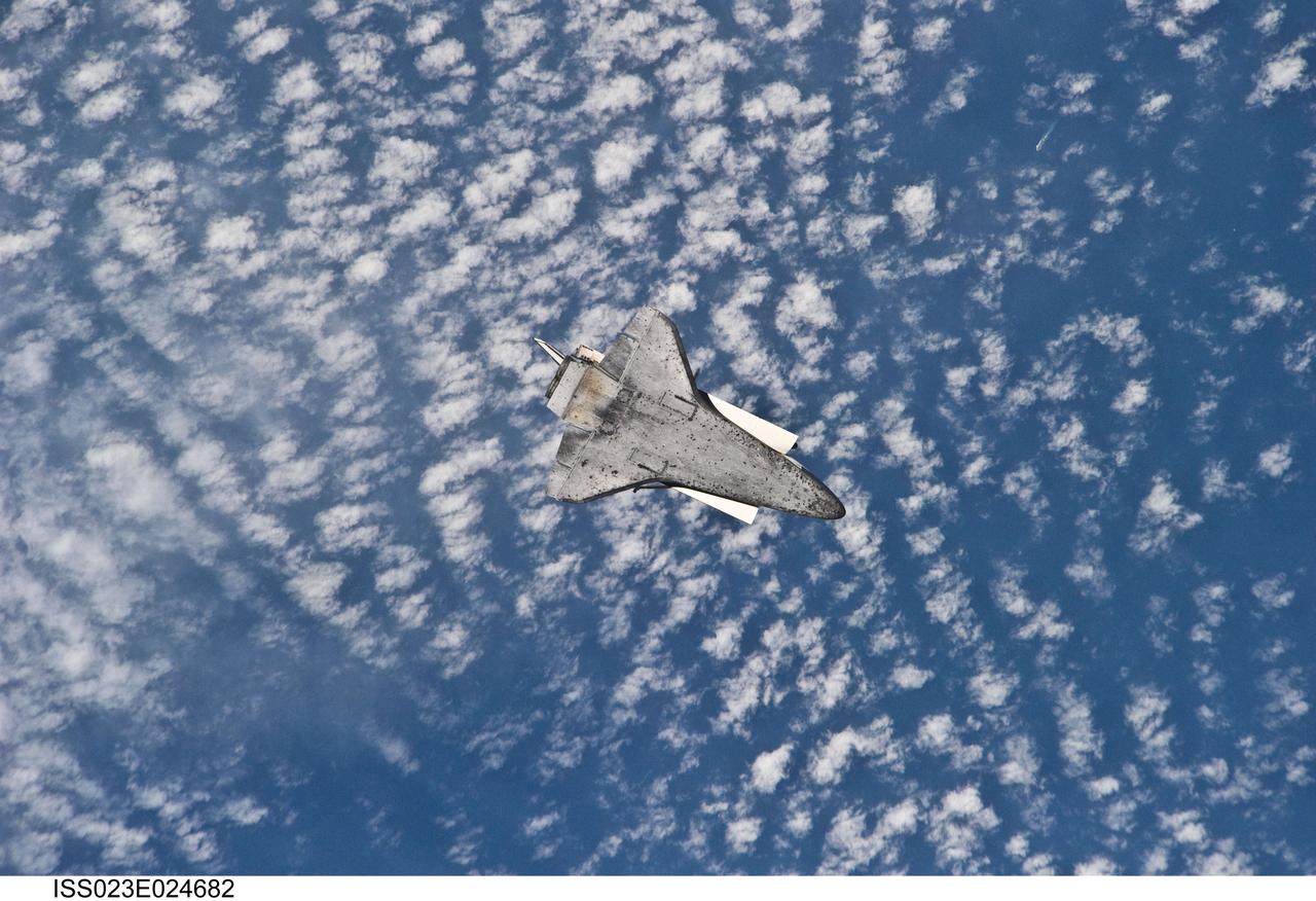 ISS023-E-024682 (17 April 2010) --- The space shuttle Discovery flies with its payload bay facing Earth so that the astronauts and cosmonauts onboard the International Space Station could survey and photograph it following the relative separation of the two spacecraft on April 17.