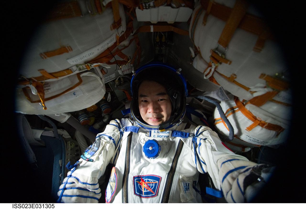 ISS023-E-031305 (3 May 2010) --- Attired in his Russian Sokol launch and entry suit, Japan Aerospace Exploration Agency (JAXA) astronaut Soichi Noguchi, Expedition 23 flight engineer, is pictured in the Soyuz 21 (TMA-17) spacecraft currently docked to the International Space Station’s Zarya nadir port. Noguchi, along with Russian cosmonaut Oleg Kotov and NASA astronaut T.J. Creamer (both out of frame) were conducting a standard suit leak check in the Soyuz spacecraft in preparation for its scheduled relocation from the Zarya nadir port to the Zvezda Service Module's aft port on May 12, 2010.