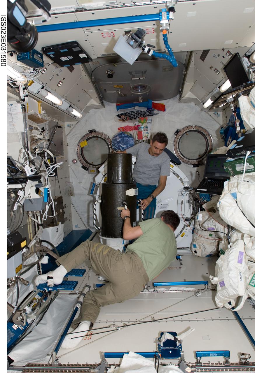 ISS023-E-031580 (4 May 2010) --- Russian cosmonauts Alexander Skvortsov (foreground) and Mikhail Kornienko, both Expedition 23 flight engineers, work with the European Matroshka-R Phantom experiment in the Kibo laboratory of the International Space Station. Matroshka, the name for the traditional Russian set of nestling dolls, is an antroph-amorphous model of a human torso designed for radiation studies.