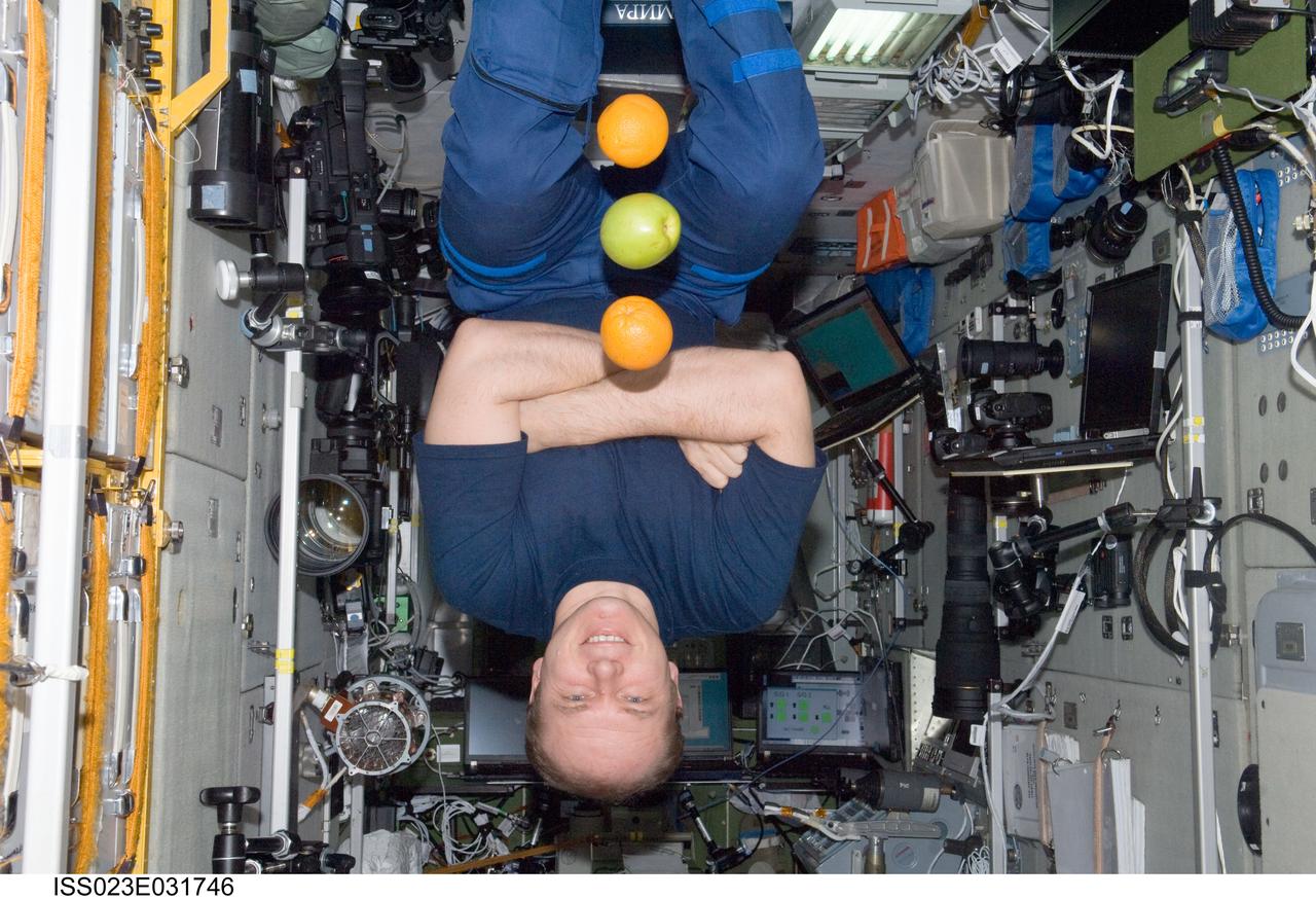 ISS023-E-031746 (1 May 2010) --- Russian cosmonaut Oleg Kotov, Expedition 23 commander, is pictured near fresh fruit floating freely in the Zvezda Service Module of the International Space Station.