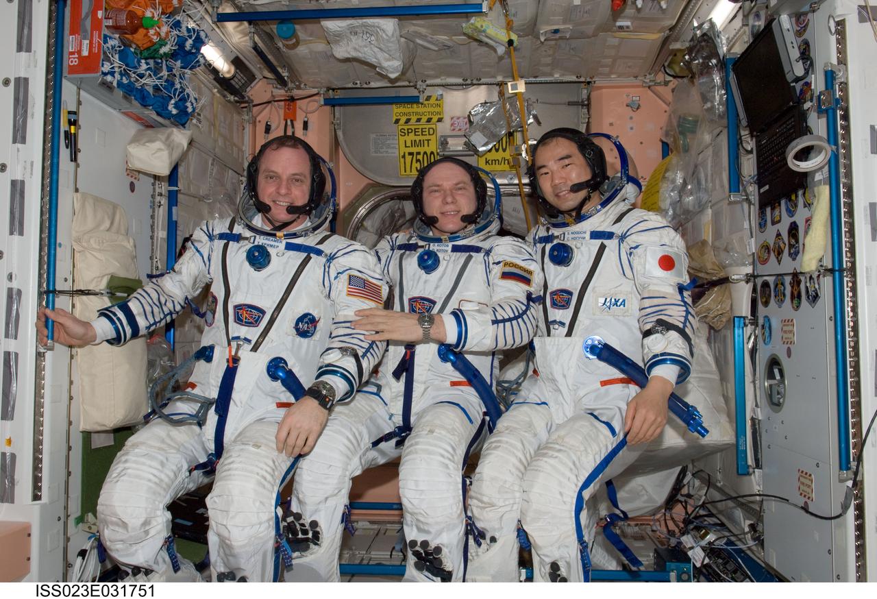 ISS023-E-031751 (3 May 2010) --- Attired in their Russian Sokol launch and entry suits, Russian cosmonaut Oleg Kotov (center), Expedition 23 commander; along with NASA astronaut T.J. Creamer (left) and Japan Aerospace Exploration Agency (JAXA) astronaut Soichi Noguchi, both flight engineers, pose for a photo in the Unity node of the International Space Station. Kotov, Noguchi and Creamer were about to conduct a standard suit leak check in preparation for the scheduled relocation of the Soyuz 21 (TMA-17) spacecraft from the Zarya nadir port to the Zvezda Service Module's aft port on May 12, 2010.