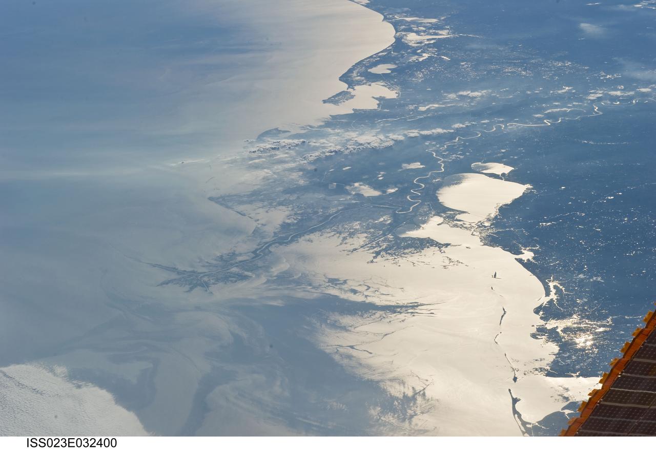 ISS023-E-032400 (4 May 2010) --- Japan Aerospace Exploration Agency (JAXA) astronaut Soichi Noguchi, Expedition 23 flight engineer, photographed the Mississippi Delta showing the oil slick in the Gulf of Mexico on May 4, 2010. Part of the river delta and nearby Louisiana coast appear dark in the sunglint. This phenomenon is caused by sunlight reflecting off the water surface, in a mirror-like manner, directly back towards the astronaut observer onboard the International Space Station (ISS). The sunglint improves the identification of the oil spill which is creating a different water texture (and therefore a contrast) between the smooth and rougher water of the reflective ocean surface. Other features which cause a change in surface roughness that can be seen in sunglint are wind gusts, naturally occurring oils that will be gathered by and take the form of water currents or wave patterns, and less windy areas behind islands.