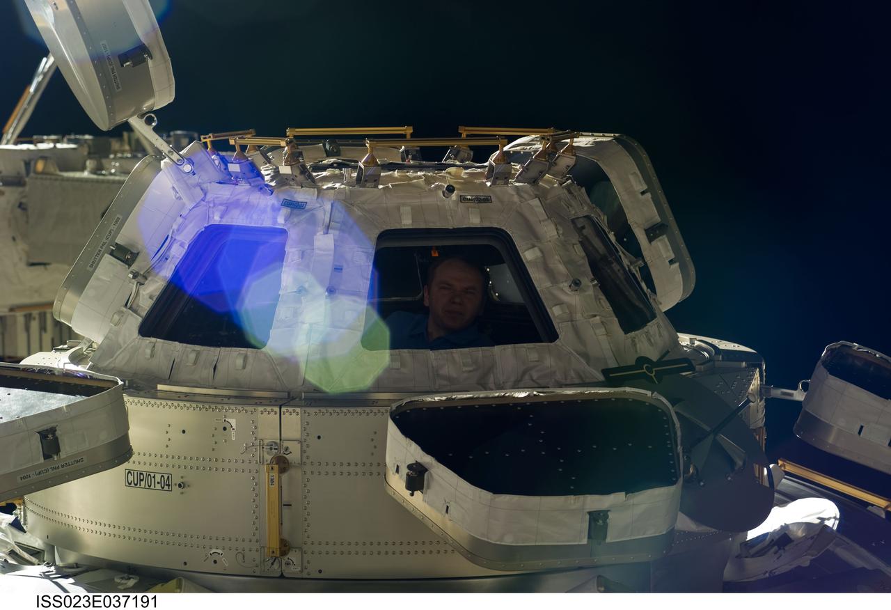 ISS023-E-037191 (9 May 2010) --- Russian cosmonaut Oleg Kotov, Expedition 23 commander, is pictured in a window of the Cupola of the International Space Station.