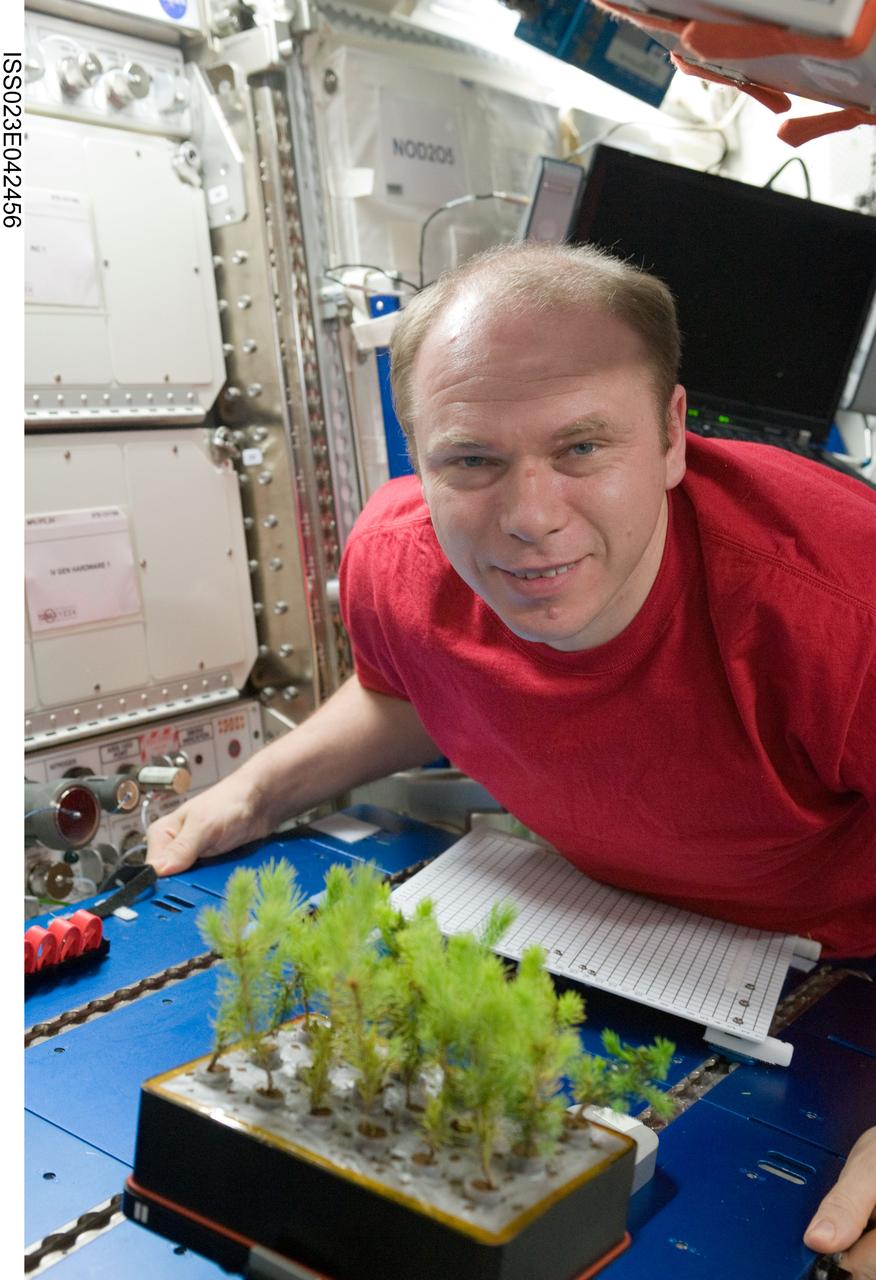ISS023-E-042456 (10 May 2010) --- Russian cosmonaut Oleg Kotov, Expedition 23 commander, poses for a photo with a plant experiment in the Destiny laboratory of the International Space Station.