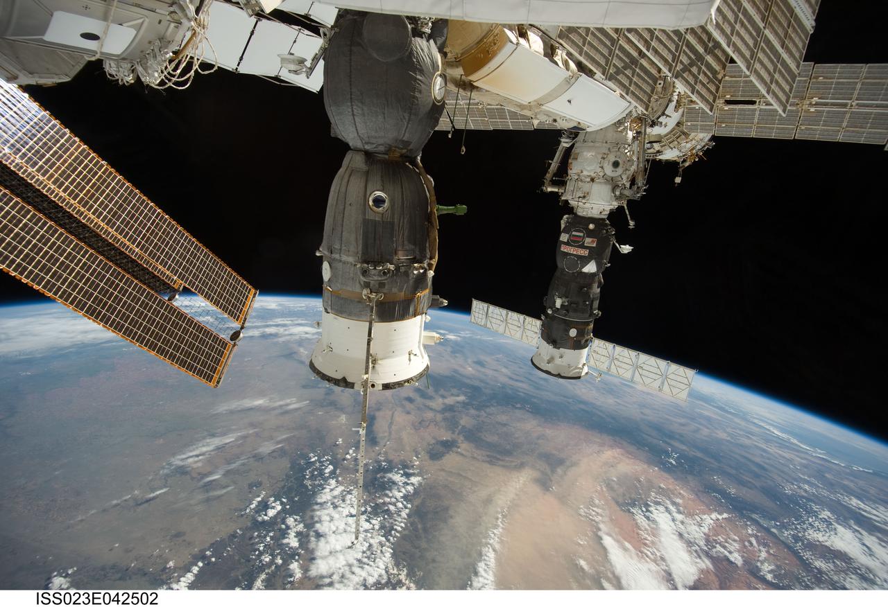 ISS023-E-042502 (11 May 2010) --- Two Russian spacecraft, docked with the International Space Station, are featured in this image photographed by an Expedition 23 crew member on the station.  Earth?s horizon and the blackness of space provide the backdrop for the scene.