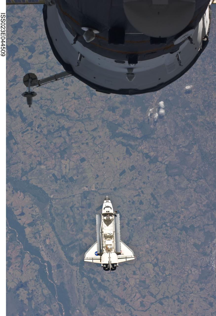 ISS023-E-044509 (16 May 2010) --- Backdropped by a colorful Earth, space shuttle Atlantis is featured in this image photographed by an Expedition 23 crew member as the shuttle approaches the International Space Station during STS-132 rendezvous and docking operations. Docking occurred at 9:28 a.m. (CDT) on May 16, 2010. A portion of a docked Russian spacecraft is visible at top.