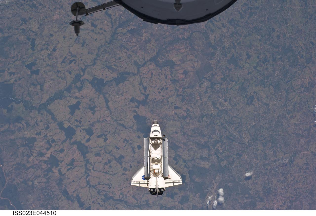 ISS023-E-044510 (16 May 2010) --- Backdropped by a colorful Earth, space shuttle Atlantis is featured in this image photographed by an Expedition 23 crew member as the shuttle approaches the International Space Station during STS-132 rendezvous and docking operations. Docking occurred at 9:28 a.m. (CDT) on May 16, 2010. A portion of a docked Russian spacecraft is visible at top.