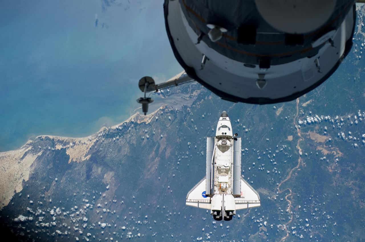 ISS023-E-044528 (16 May 2010) --- Flying above coastal dunes along the Brazilian coast, the space shuttle Atlantis is shown making its relative approach to the International Space Station, from which this photo was taken. The city of Rutoia is close to the bay near the center of the image and the sandy meanders of the Rio Parnaiba. Center point coordinates of the image are 2.9 degrees south latitude and 42.2 degrees west longitude. Photo credit: NASA or National Aeronautics and Space Administration