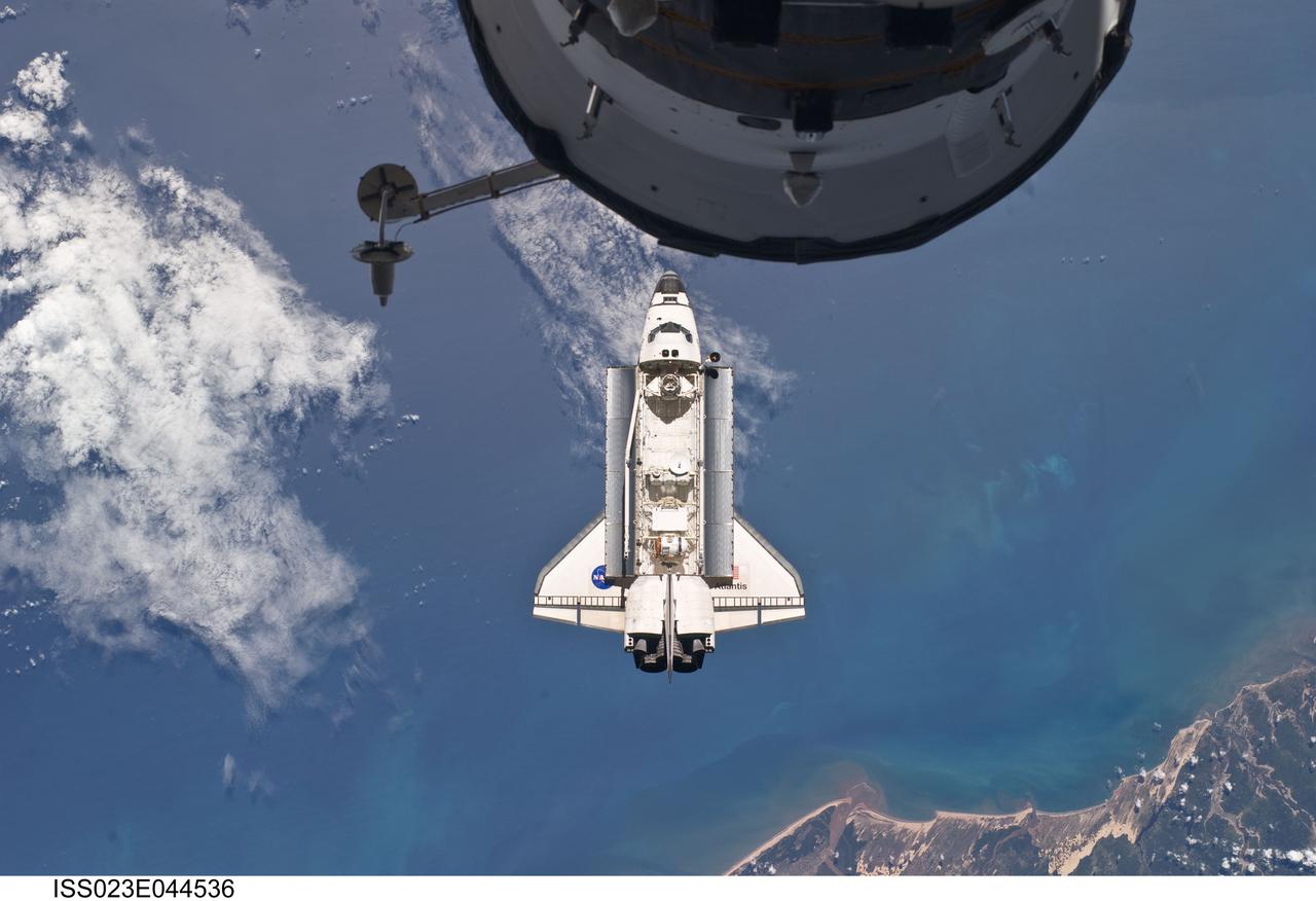 ISS023-E-044536 (16 May 2010) --- Backdropped by a colorful Earth, space shuttle Atlantis is featured in this image photographed by an Expedition 23 crew member as the shuttle approaches the International Space Station during STS-132 rendezvous and docking operations. Docking occurred at 9:28 a.m. (CDT) on May 16, 2010. A portion of a docked Russian spacecraft is visible at top.