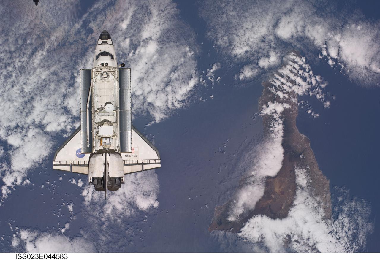 ISS023-E-044583 (16 May 2010) --- Backdropped by a colorful Earth, space shuttle Atlantis is featured in this image photographed by an Expedition 23 crew member as the shuttle approaches the International Space Station during STS-132 rendezvous and docking operations. Docking occurred at 9:28 a.m. (CDT) on May 16, 2010. Tenerife in the Canary Island chain is visible below.