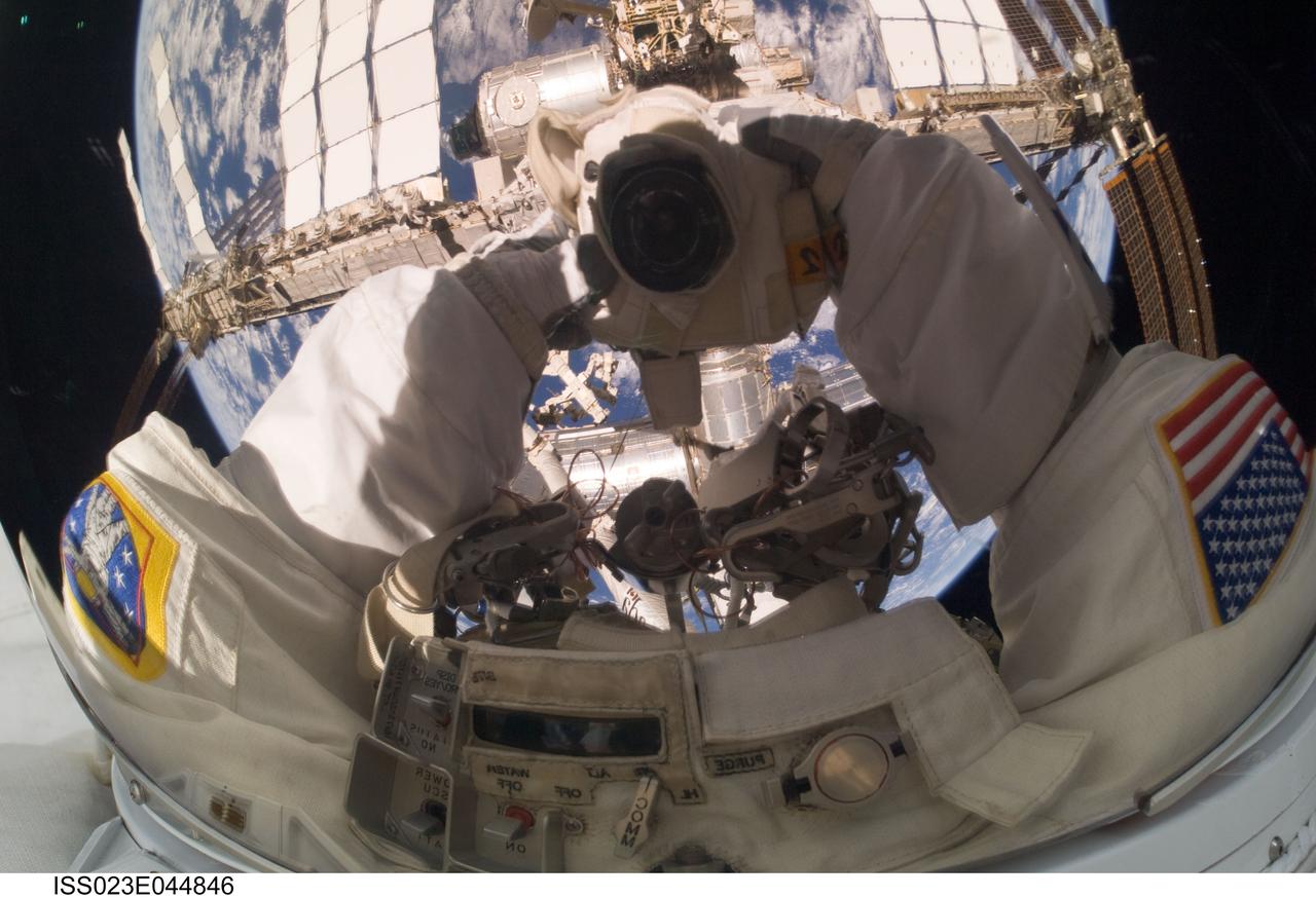 ISS023-E-044846 (17 May 2010) --- NASA astronaut Garrett Reisman, STS-132 mission specialist, takes a busy "self portrait" into his helmet visor while participating in the first of three spacewalks scheduled for the Atlantis crew and their Expedition 23 hosts. Though three sessions of extravehicular activity (EVA) will involve only three astronauts (two on each occasion) who actually leave the shirt-sleeve environments of the two docked spacecraft, all twelve astronauts and cosmonauts have roles in supporting the EVA work. Part of the space station and the blue and white Earth are among the objects seen in his visor. Astronaut Steve Bowen, mission specialist, is out of frame. Photo credit: NASA or National Aeronautics and Space Administration
