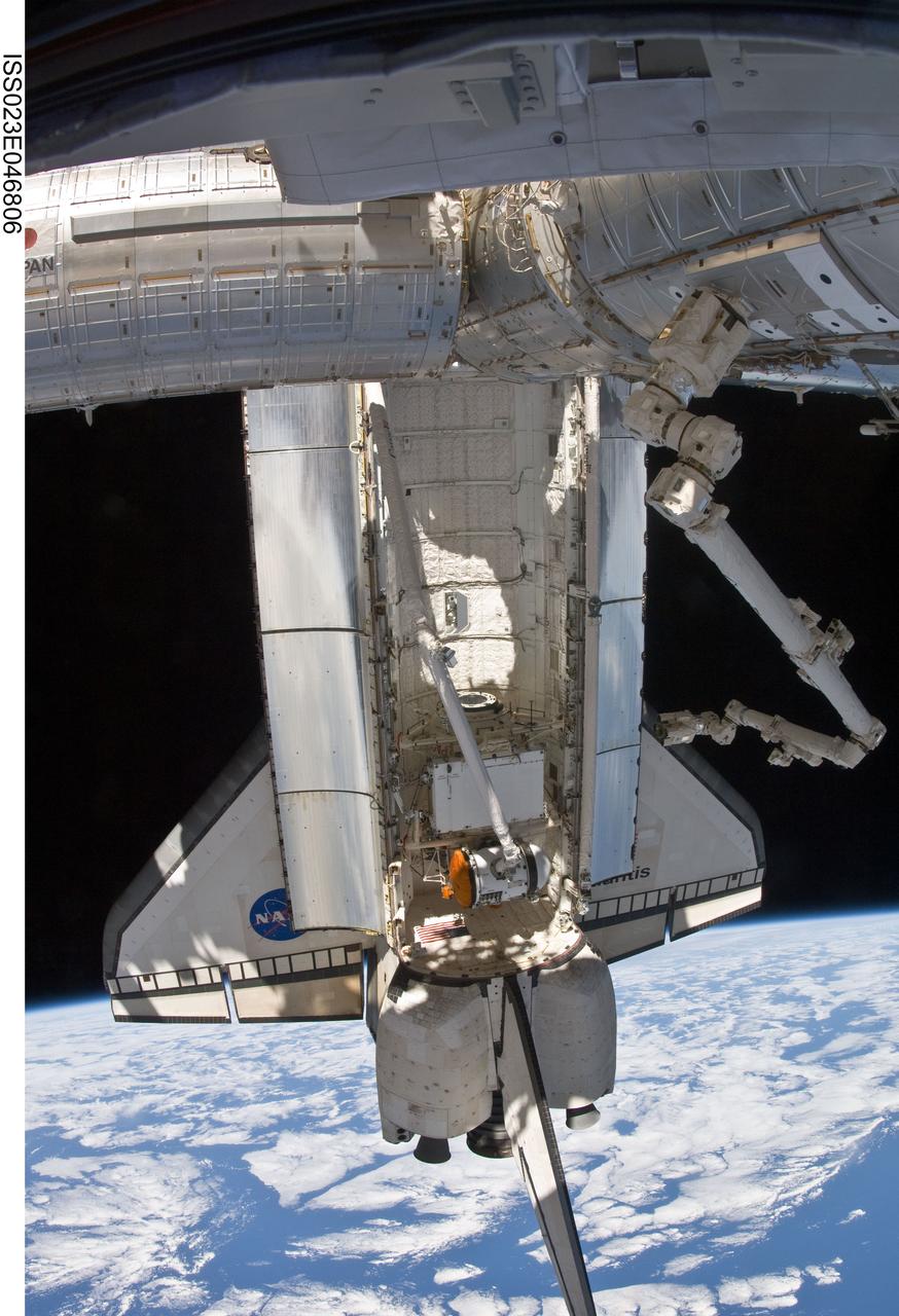 ISS023-E-046806 (18 May 2010) --- Backdropped by Earth?s horizon and the blackness of space, the docked space shuttle Atlantis is featured in this image photographed by an Expedition 23 crew member on the International Space Station. The Russian-built Mini-Research Module 1 (MRM-1) is visible in the payload bay as the shuttle robotic arm prepares to unberth the module from Atlantis and position it for handoff to the station robotic arm (visible at right). Named Rassvet, Russian for "dawn," the module is the second in a series of new pressurized components for Russia and will be permanently attached to the Earth-facing port of the Zarya Functional Cargo Block (FGB). Rassvet will be used for cargo storage and will provide an additional docking port to the station.