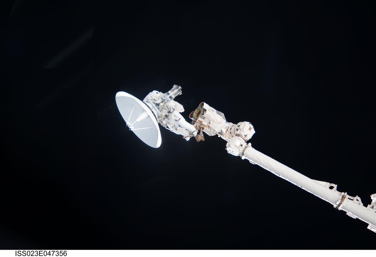 ISS023-E-047356 (17 May 2010) --- Anchored to a Canadarm2 mobile foot restraint, NASA astronaut Garrett Reisman, STS-132 mission specialist, participates in the mission's first session of extravehicular activity (EVA) as construction and maintenance continue on the International Space Station. During the seven-hour, 25-minute spacewalk, Reisman and NASA astronaut Steve Bowen (out of frame), mission specialist, loosened bolts holding six replacement batteries, installed a second antenna for high-speed Ku-band transmissions and adding a spare parts platform to Dextre, a two-armed extension for the station?s robotic arm.