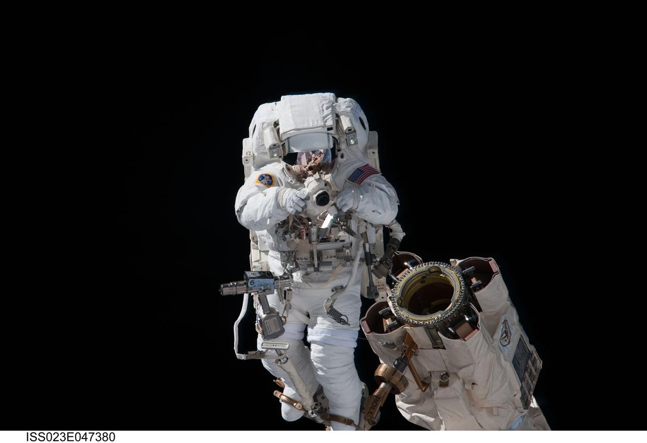 ISS023-E-047380 (17 May 2010) --- Anchored to a Canadarm2 mobile foot restraint, NASA astronaut Garrett Reisman, STS-132 mission specialist, uses a still camera during the mission's first session of extravehicular activity (EVA) as construction and maintenance continue on the International Space Station. During the seven-hour, 25-minute spacewalk, Reisman and NASA astronaut Steve Bowen (out of frame), mission specialist, loosened bolts holding six replacement batteries, installed a second antenna for high-speed Ku-band transmissions and adding a spare parts platform to Dextre, a two-armed extension for the station?s robotic arm.
