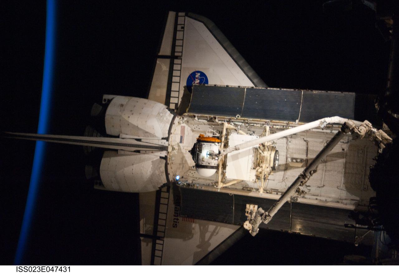 ISS023-E-047431 (18 May 2010) --- Intersecting the thin line of Earth's atmosphere, the docked space shuttle Atlantis is featured in this image photographed by an Expedition 23 crew member on the International Space Station. The Russian-built Mini-Research Module 1 (MRM-1) is visible in the payload bay as the shuttle robotic arm prepares to unberth the module from Atlantis and position it for handoff to the station robotic arm. Named Rassvet, Russian for "dawn," the module is the second in a series of new pressurized components for Russia and will be permanently attached to the Earth-facing port of the Zarya Functional Cargo Block (FGB). Rassvet will be used for cargo storage and will provide an additional docking port to the station.