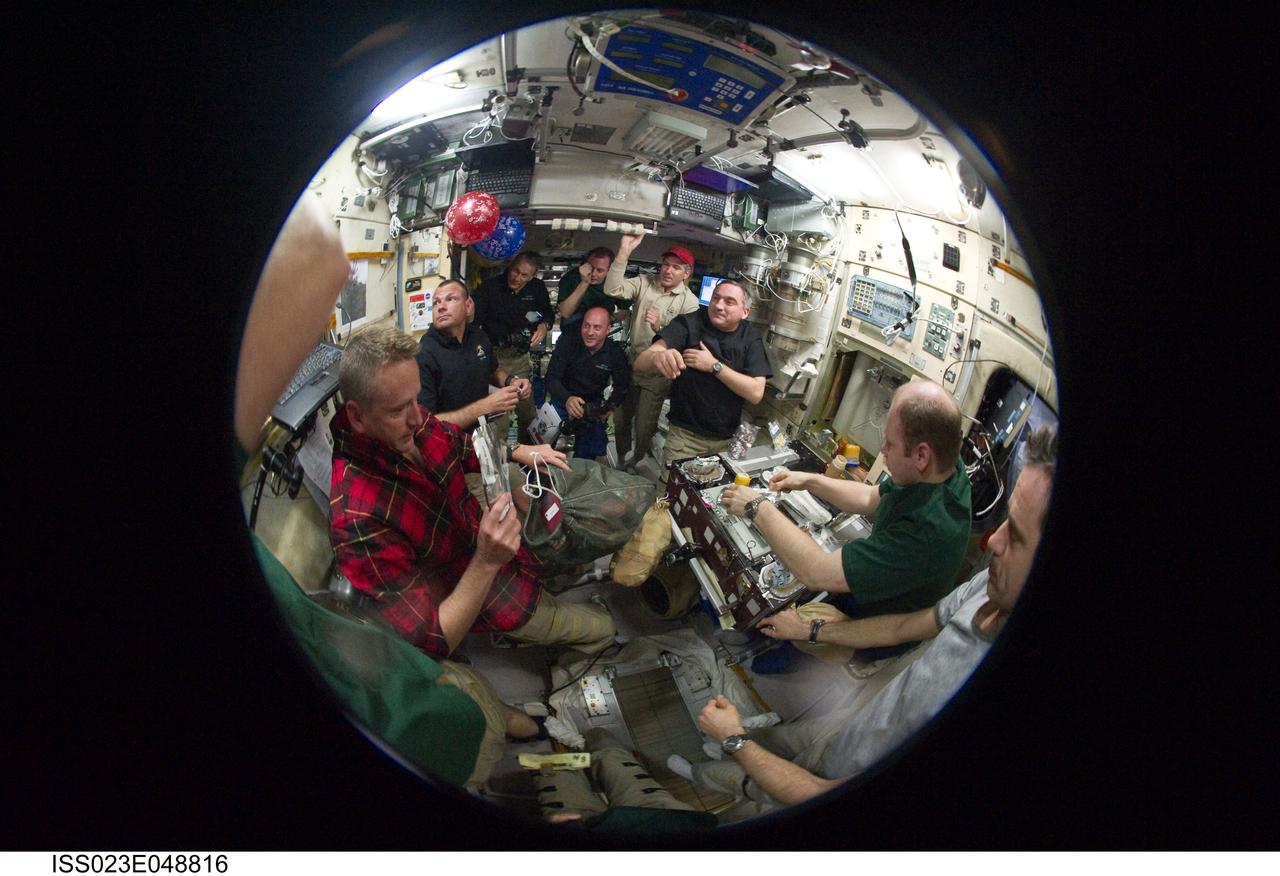 ISS023-E-048816 (19 May 2010) --- A fish-eye lens attached to an electronic still camera was used to capture this image of STS-132 and Expedition 23 crew members as they share a meal in the Zvezda Service Module of the International Space Station while space shuttle Atlantis remains docked with the station. Pictured in the foreground (left to right) are NASA astronaut Ken Ham, STS-132 commander; along with Russian cosmonauts Oleg Kotov, Expedition 23 commander; and Mikhail Kornienko (mostly out of frame), Expedition 23 flight engineer. Pictured in the background are NASA astronauts Tony Antonelli, STS-132 pilot; Piers Sellers, Garrett Reisman and Michael Good, all STS-132 mission specialists; along with NASA astronaut T.J. Creamer and Russian cosmonaut Alexander Skvortsov, both Expedition 23 flight engineers.